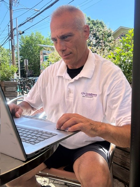 Kevin Mohan working on a laptop for CodeBreeze Solutions